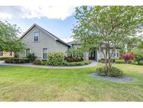 Landscaped front yard featuring lush lawn, stone walkway, and mature trees creating an inviting curb appeal at 6347 Ashley Dr, Lakeland, FL 33813