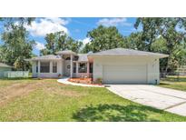 Charming single-story home featuring a well-manicured lawn and an attached two-car garage at 6735 Forestwood W Dr, Lakeland, FL 33811