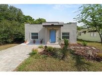 Charming home featuring a blue front door, well-maintained landscaping, and a paved walkway and driveway at 705 W Park St, Lakeland, FL 33803