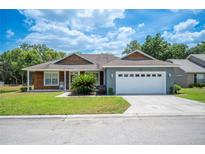 Well-maintained home with a two-car garage, manicured lawn, and inviting front porch at 7088 Remington Oaks Loop, Lakeland, FL 33810