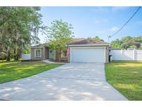 Charming home featuring an attached two-car garage, and a well-maintained front yard at 818 Fairlane Dr, Lakeland, FL 33809
