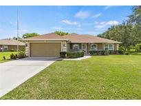 Charming single-story home featuring a well-maintained lawn and attached two-car garage at 1519 Blue Sky Blvd, Haines City, FL 33844