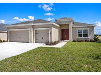 Charming single-story home with a two-car garage, neat landscaping, and a well-maintained lawn at 2033 Summerlake Dr, Auburndale, FL 33823