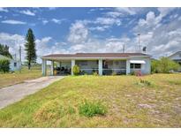 Charming single-story home with a covered carport and quaint front porch, set against a cloudy sky at 224 Raymond Ave, Frostproof, FL 33843