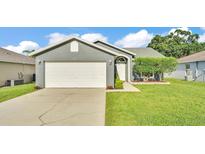 Charming single-story home featuring a two-car garage and well-maintained front lawn at 242 Kings Pond Sw Ave, Winter Haven, FL 33880