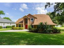 Charming two-story home boasting lush landscaping, manicured lawn, and classic architectural details at 254 Lake Tennessee Dr, Auburndale, FL 33823