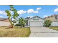 Charming single-story home with a two-car garage, palm tree, and neatly maintained lawn at 412 Emerald Cove Loop, Lakeland, FL 33813