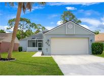Charming single-Gathering home featuring a two-car garage, well-maintained lawn, and inviting screened porch at 432 Sandestin Dr, Winter Haven, FL 33884