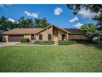 Charming brick home with a well-manicured lawn and inviting landscaping at 4825 Luce Rd, Lakeland, FL 33813