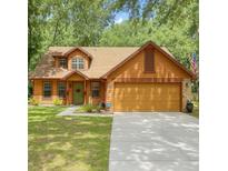 Charming two-story home featuring a well-manicured lawn, a green front door, and a spacious two-car garage at 5619 Antler Trl, Lakeland, FL 33811