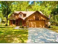 Charming two-story home with a well-manicured lawn, mature trees, and an attached two-car garage at 5619 Antler Trl, Lakeland, FL 33811