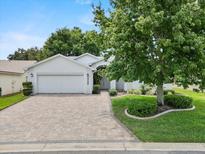 Charming single-story home with a well-manicured lawn, brick driveway, and mature landscaping at 6086 Swallow Dr, Lakeland, FL 33809