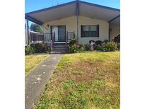 Cozy single-story home featuring covered entrance, well-maintained lawn, and landscaped garden beds at 612 Forest Lake Dr, Lakeland, FL 33809
