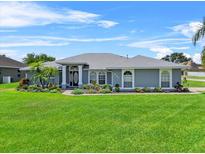 Charming single-story home featuring a well-manicured lawn and beautiful landscaping at 647 Hart Lake Dr, Winter Haven, FL 33884