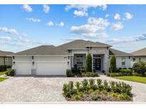 Beautiful single-story home boasts a three-car garage, manicured landscaping, and a stone-accented entryway at 6777 Bentridge Dr, Lakeland, FL 33813