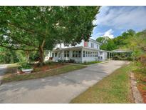 Charming two-story home with a covered front porch, lush landscaping, and a long driveway at 716 S Franklin Pl, Lakeland, FL 33815