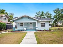 Charming craftsman-style home featuring a quaint front porch, blue siding, and a well-manicured front lawn at 717 Frank Lloyd Wright Way, Lakeland, FL 33803