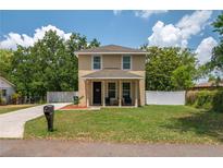 Inviting two-story home featuring a well-manicured lawn, cozy porch, and classic architectural design at 1105 Watersedge Dr, Lakeland, FL 33801