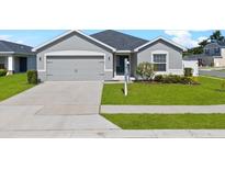 Charming single-story home with a well-manicured lawn and a two-car garage in a suburban neighborhood at 1106 Tropea Ln, Auburndale, FL 33823