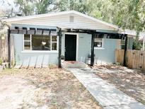 Charming single-story home featuring black door, wood pergola, and easy to maintain landscaping at 1160 Austin St, Bartow, FL 33830