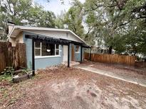 Charming single-story home featuring a pergola, wood fence, and drought-tolerant landscaping at 1160 Austin St, Bartow, FL 33830