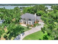 Aerial view of a beautiful two-story home with a well-manicured lawn and lush landscaping near a lake at 1218 Lake Point Ter, Lakeland, FL 33813