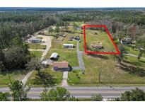 Expansive property featuring a charming home with a generous yard and lush surroundings at 2323 State Road 33, Clermont, FL 34714