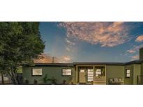 Charming, green single-story home with a welcoming front porch and landscaped yard at 2705 N Martha Ave, Lakeland, FL 33805