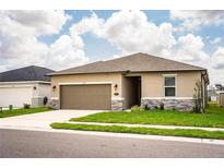 Beautiful single-Gathering home with a two-car garage, well-maintained lawn and stylish stone accents at 297 Spirit Landings Cir, Winter Haven, FL 33880