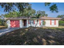 Charming single-story home with a red garage door and a well-maintained front yard at 526 Marklen Loop, Polk City, FL 33868