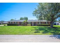 Charming single-story brick home with mature trees, manicured lawn, and classic curb appeal at 5604 Stratford Ln, Lakeland, FL 33813