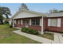 Charming brick home featuring a cozy front porch, white accents, and well-maintained landscaping at 6131 Doe E Cir, Lakeland, FL 33809