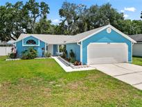 Charming blue home with well-kept lawn, two-car garage, and beautiful landscaping at 6810 Palomino Dr, Lakeland, FL 33811