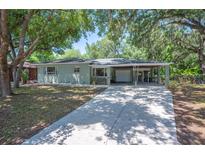Charming home featuring a large driveway, a carport, and mature trees, offering a serene and inviting atmosphere at 921 Avon Ave, Lakeland, FL 33801