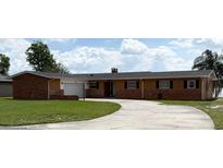 Charming single-story home featuring a brick and siding exterior, well-manicured lawn, and a spacious driveway at 1208 W Lake Buckeye Dr, Winter Haven, FL 33881