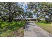 Charming brick home with mature trees and a long driveway at 1317 Old Polk City Rd, Lakeland, FL 33809