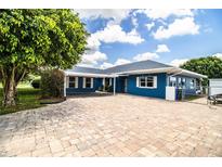 Charming blue home features a brick driveway, carport, and well-maintained landscaping at 1328 Edgewater Beach Dr, Lakeland, FL 33805