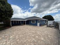 Inviting blue single-story home featuring a spacious brick driveway and well-maintained landscaping at 1328 Edgewater Beach Dr, Lakeland, FL 33805