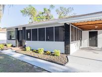Charming single-story home featuring a screened porch and fresh landscaping at 1507 Holly Rd, Lakeland, FL 33801