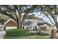 Charming one-story home featuring manicured landscaping and a mature tree canopy at 1516 Jae Pl, Lakeland, FL 33803