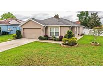 Charming single-Gathering home featuring well-maintained landscaping and a two-car garage at 2040 Chickadee St, Bartow, FL 33830