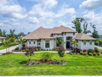 Stunning two-story home with manicured lawn, mature trees, and colorful flower beds offering great curb appeal at 2662 Delphi Hills Ct, Lakeland, FL 33812