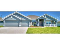 Charming home featuring a three-car garage, manicured lawn, and inviting covered porch at 4019 Tullamore Ln, Auburndale, FL 33823