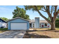 Charming single-story home with a well-maintained lawn, a two-car garage and mature shade tree at 417 Yolonda Ct, Lakeland, FL 33809