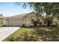 Charming single-story home with a well-maintained lawn, mature trees, and an attached two-car garage at 5733 Oakwood Knoll Dr, Lakeland, FL 33811