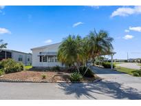 Well-maintained home featuring a driveway, carport, and tropical landscaping at 6731 Canterbury Ne Dr, Winter Haven, FL 33881