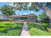 Charming home with a screened porch, well-manicured lawn, and inviting brick walkway at 916 Woodward St, Lakeland, FL 33803