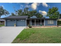 Charming single-story home featuring a screened porch, attached garage, and well-maintained lawn at 1920 Indian Trails Ct, Lakeland, FL 33813
