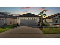 Two-car garage with decorative details and palm trees in a well-maintained front yard during dusk at 2293 Caspian Dr, Lakeland, FL 33805