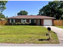 Charming single-story brick home with a well-manicured lawn and attached garage at 2323 Ridgeview Dr, Lakeland, FL 33810